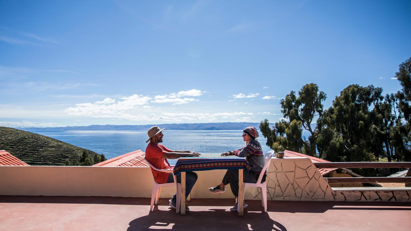 Two people sitting on a terrace overlooking Lake Titicaca in La Paz, Bolivia.